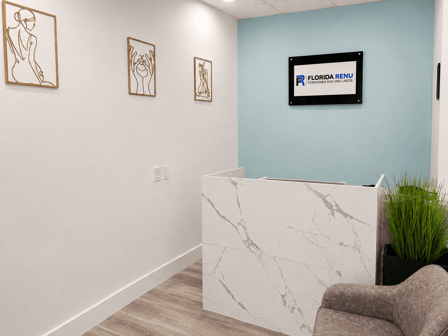 Reception area with gold wall art and marble desk at Florida Renu