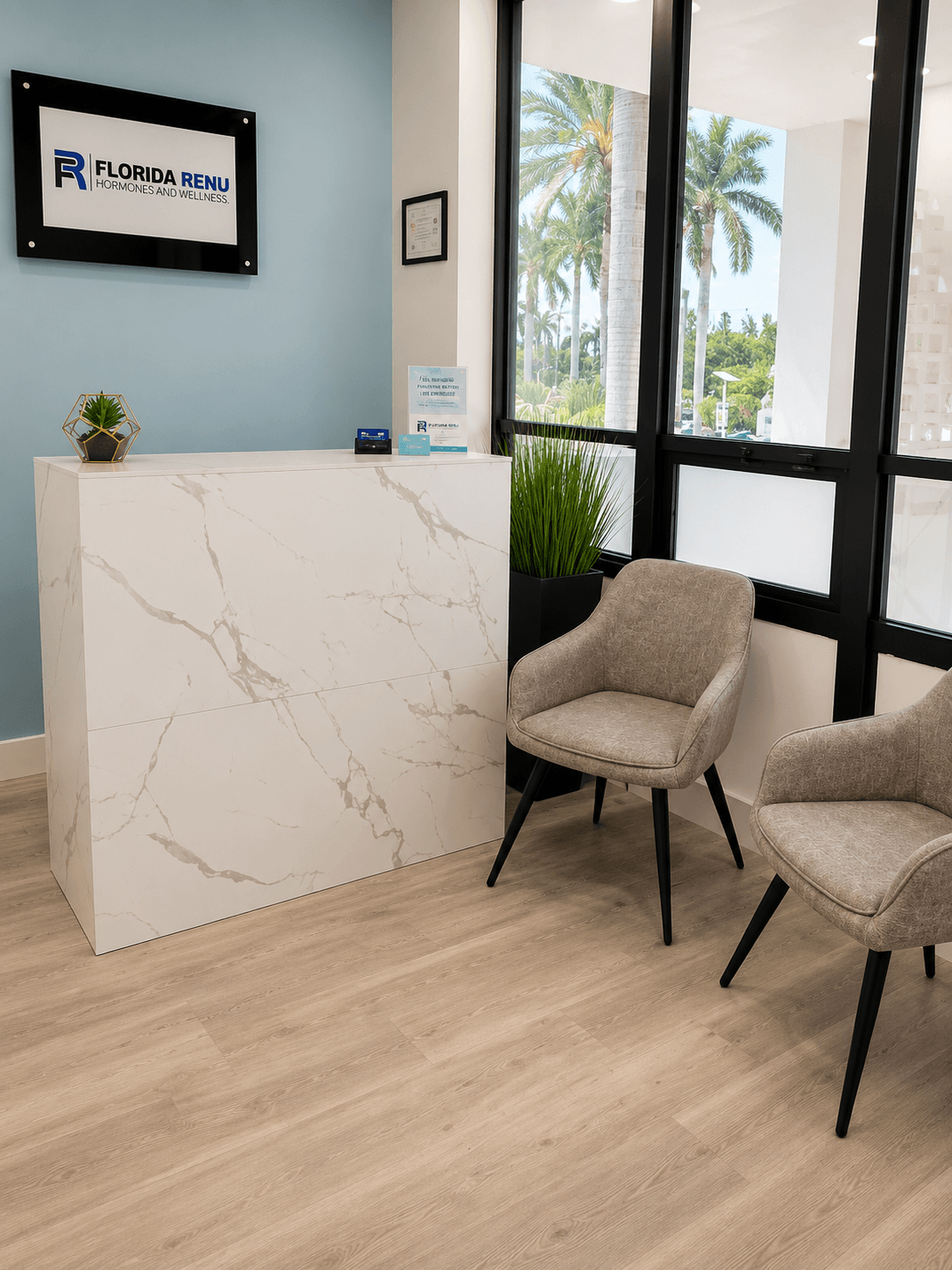 Waiting area with grey chairs and palm tree views at Florida Renu